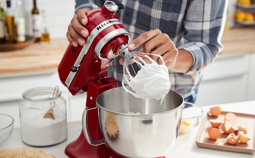 A stand mixer whipping glossy meringue peaks to perfection.