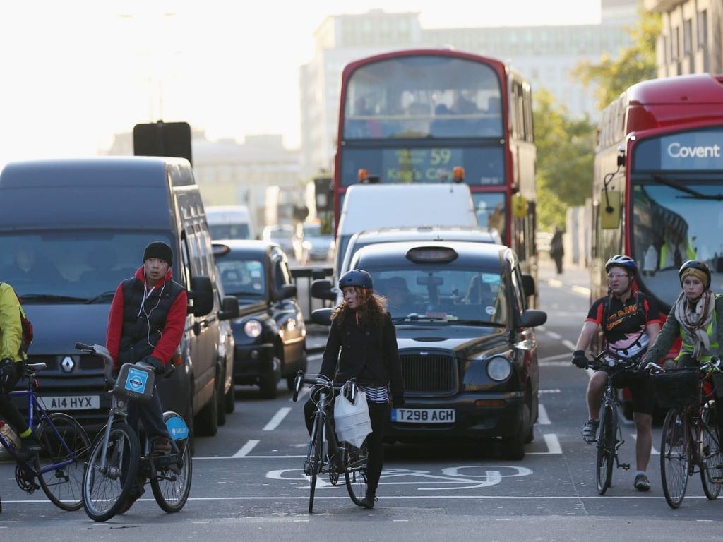 Cyclist riding to the office on a bike lane, showing the benefits of biking over driving a car