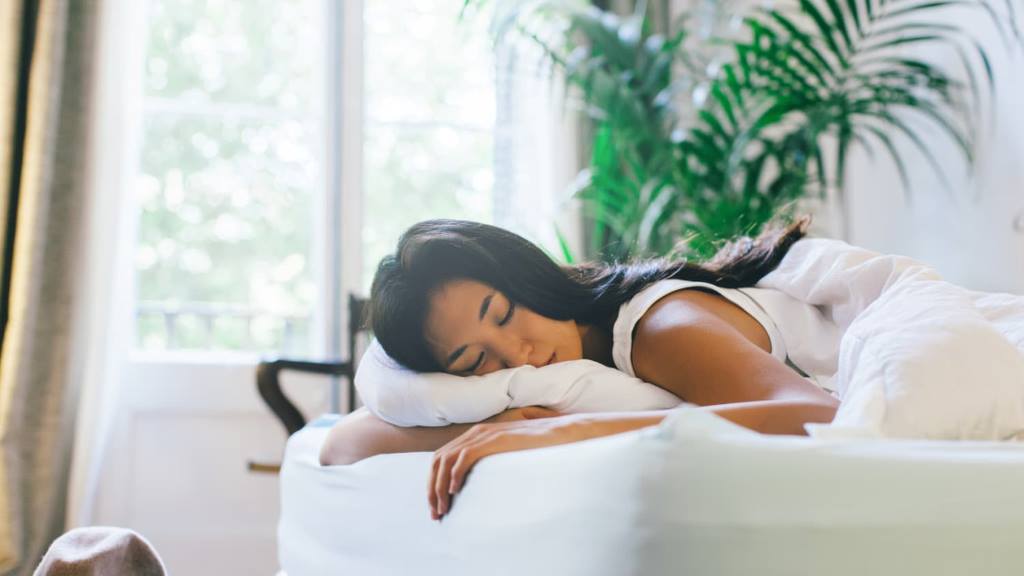 Woman sleeping peacefully on LOFE organic buckwheat pillow with adjustable loft