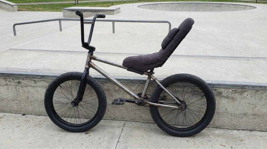 Padded adult pivotal BMX seat angled upward on a professional street bike frame.