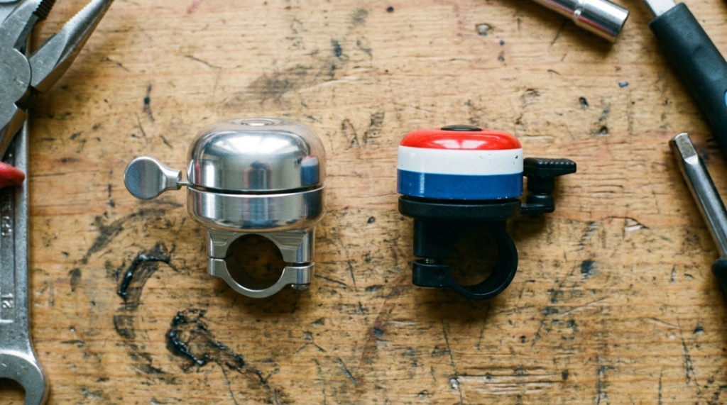 Side-by-side comparison of an aluminum bell and standard bike bell.